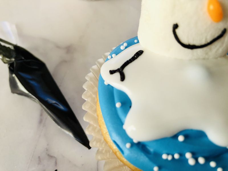 Melted snowman cupcake adding arms